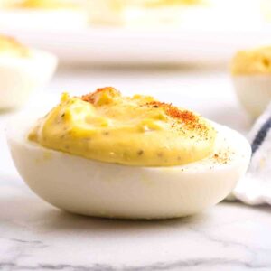 A finished deviled egg on a white plate.